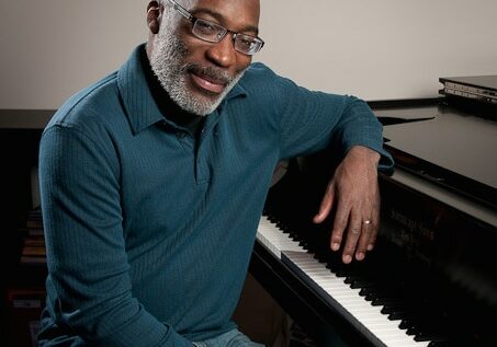 Portland jazz pianist Darrell Grant poses at the piano in his office at Portland State University Dec. 5, 2011. (Photo by Matthew Ginn for NW Boomer &amp; Senior News)